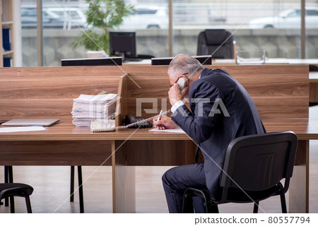 Old male employee sitting in the office 80557794