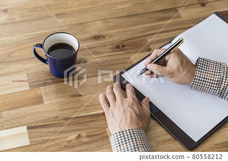 一個 50 多歲的男人用鋼筆的手 80558212