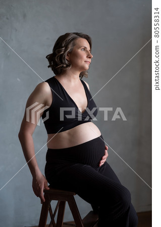 Pregnant caucasian woman posing in studio during photoshoot. 80558314