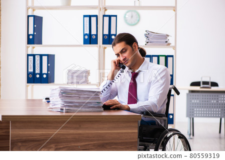Young male employee after accident in wheel-chair at workplace Young male employee after accident in wheel-chair at workplace 80559319