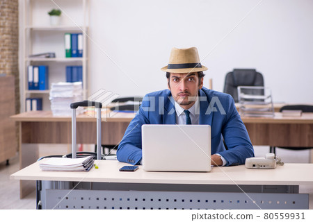 Young male employee preparing for trip in the office 80559931