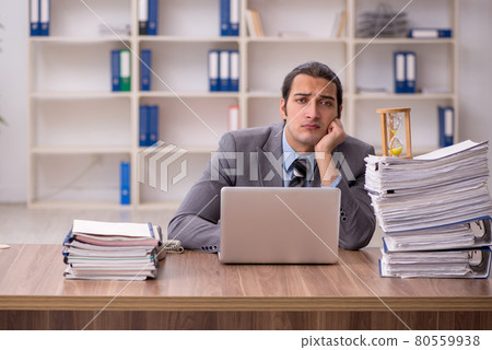 Young male employee in time management concept Young male employee in time management concept 80559938