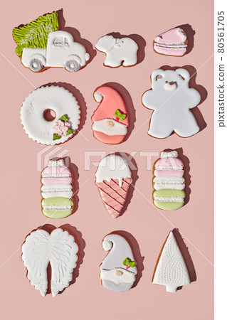Gingerbreads of different shapes with sugar icing on pinkish background Gingerbreads of different shapes with sugar icing on pinkish background 80561705