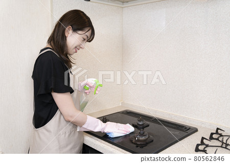 Woman cleaning the gas stove 80562846