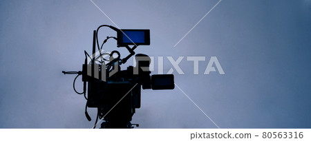 Video production behind the scenes. Making of TV commercial movie that film crew team lightman and cameraman working together with film director in studio. film production concept. Silhouette style. 80563316