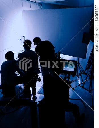 Video production behind the scenes. Making of TV commercial movie that film crew team lightman and cameraman working together with film director in studio. film production concept. Silhouette style. 80563321