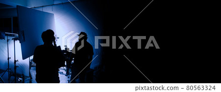 Video production behind the scenes. Making of TV commercial movie that film crew team lightman and cameraman working together with film director in studio. film production concept. Silhouette style. Video production behind the scenes. Making of TV commercial movie that film crew team lightman and cameraman working together with film director in studio. film production concept. Silhouette style. 80563324