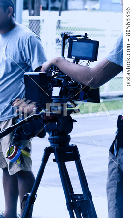 Video production behind the scenes. Making of TV commercial movie that film crew team lightman and cameraman working together with film director in studio. film production concept. Silhouette style. 80563336