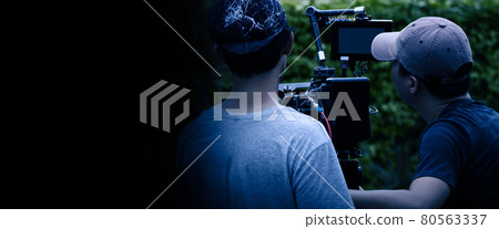 Video production behind the scenes. Making of TV commercial movie that film crew team lightman and cameraman working together with film director in studio. film production concept. Silhouette style. 80563337