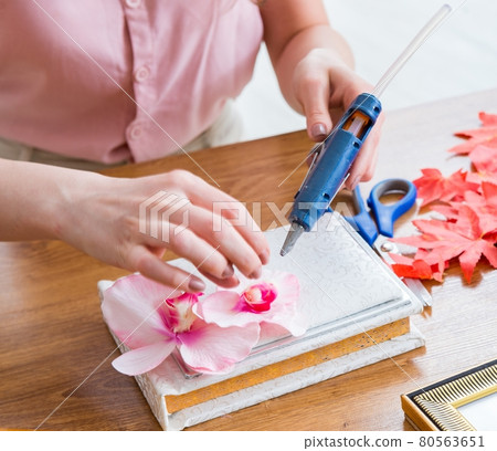 Woman decorating picture frame in scrapbooking concept Woman decorating picture frame in scrapbooking concept 80563651