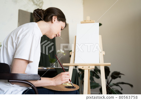 The artist mixes oil paints on the palette. Professional tools of the painter The artist mixes oil paints on the palette. Professional tools of the painter 80563758