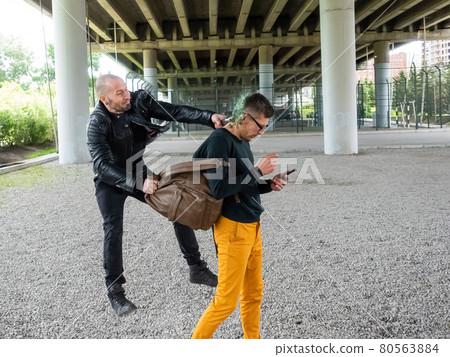 The thug breaks the bottle on the man's head and steals the backpack. Attack with the purpose of theft 80563884