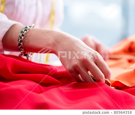 Woman tailor working on new dress designs Woman tailor working on new dress designs 80564358