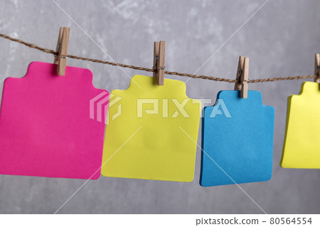 Blank varicoloured paper cards hang with clothespin on rope. Copy space. Place for your text. Blank varicoloured paper cards hang with clothespin on rope. Copy space. Place for your text. 80564554