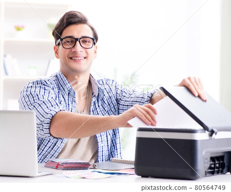 Young man employee working at copying machine in the office Young man employee working at copying machine in the office 80564749