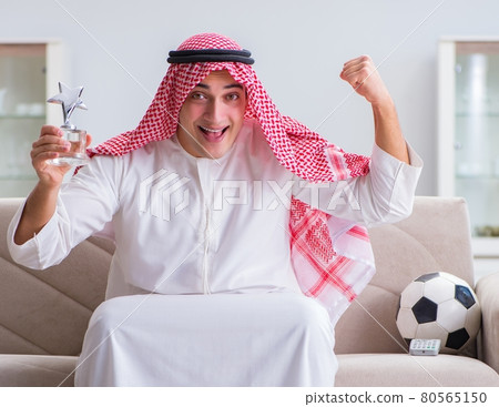 Arab man watching sport football at tv 80565150