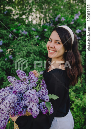 beautiful woman posing with lilac flowers 80565463