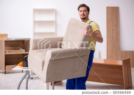 Young male carpenter repairing arm-chair in the office 80566499