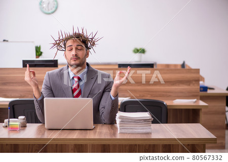 Young male employee wearing prickly wreath on head 80567332