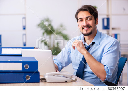 Young male employee and too much work in the office 80568907