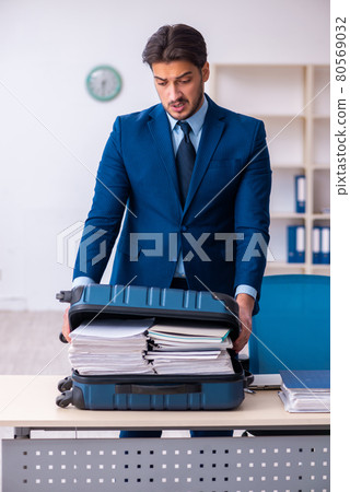 Young male employee preparing for business trip at workplace 80569032