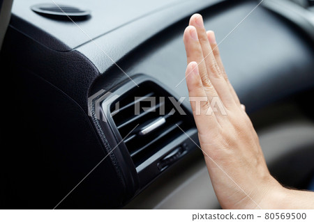 Female hand checking the cooling of the air conditioner in the car 80569500