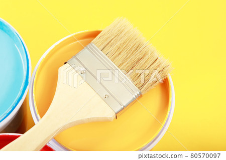The cans of interior wall paint is placed on a yellow background. 80570097