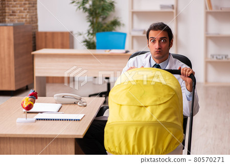 Young male doctor looking after new born in the clinic 80570271