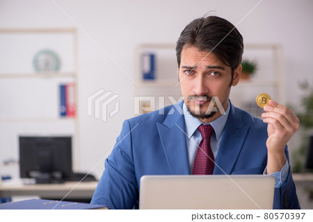 Young man earning money via Internet in cryptocurrency concept Young man earning money via Internet in cryptocurrency concept 80570397