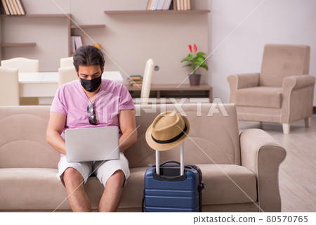Young man preparing for trip at home during pandemic Young man preparing for trip at home during pandemic 80570765