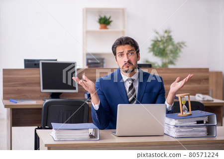 Young male employee in time management concept Young male employee in time management concept 80571224