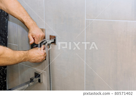 Installing a new on shower mixer tap in a bathroom 80571402
