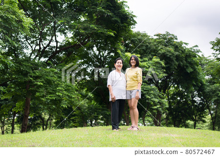 Portrait of middle aged asian woman with daughter standing at park together,Happy and smiling,Positive thinking,Take care and support concept 80572467