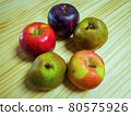Several kinds of apples placed on a wooden desk 80575926