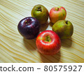 Several kinds of apples placed on a wooden desk 80575927