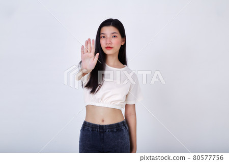 Young serious beautiful woman showing stop sign Young serious beautiful woman showing stop sign 80577756