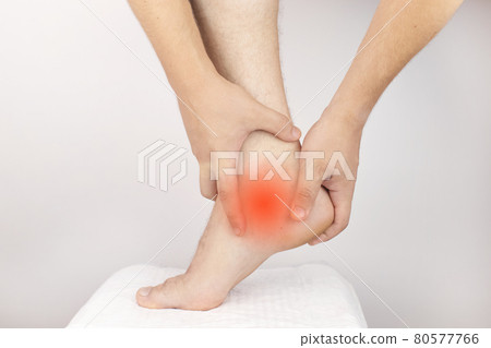 The man is experiencing acute pain in the heel. Achilles tendon sprain. Foot injuries. Heel spur, muscle strain, tendon injury or micro cracks The man is experiencing acute pain in the heel. Achilles tendon sprain. Foot injuries. Heel spur, muscle strain, tendon injury or micro cracks 80577766