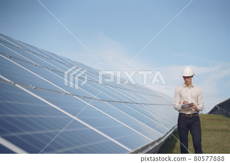 Businessman in a white helmet near solar battery Businessman in a white helmet near solar battery 80577888