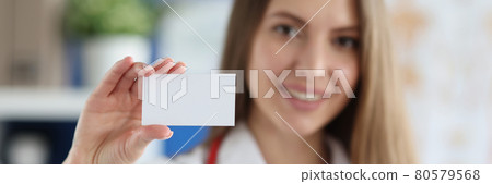 Smiling female doctor holding white business card 80579568