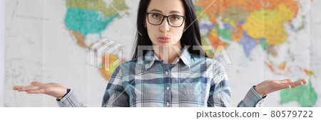 Upset surprised woman shrugs against backdrop of tourist map of world Upset surprised woman shrugs against backdrop of tourist map of world 80579722