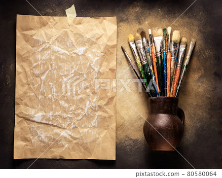 Paint brush in clay jug and palette on wooden table background. Oil painting  and art still life Stock Photo by seregam