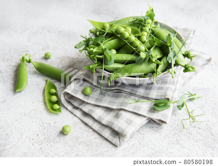 Fresh green peas pods and green peas with sprouts on concrete background. Fresh green peas pods and green peas with sprouts on concrete background. 80580198