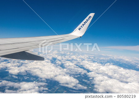 Wing of a Ryanair airplane above the clouds Wing of a Ryanair airplane above the clouds 80580219