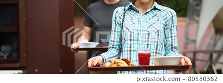 Woman and man are carrying food trays 80580362