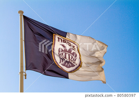 Greece, Thessaloniki, Flag on blue sky background of PAOK Salonika at football stadium 80580397