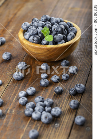 Freshly picked blueberries in wooden bowl on a wooden table. Freshly picked blueberries in wooden bowl on a wooden table. 80580839