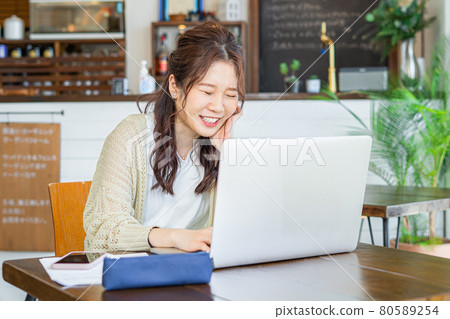 Young woman laughing while working Young woman laughing while working 80589254
