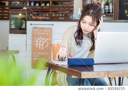 A woman who thinks while looking at documents A woman who thinks while looking at documents 80589255