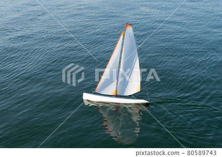 Freedom of sail. Toy yacht sail in sea. Sailing toy boat Freedom of sail. Toy yacht sail in sea. Sailing toy boat 80589743