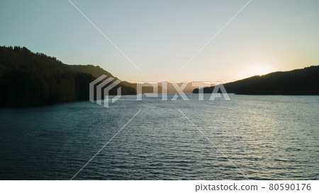 Bird's-eye view of the sunrise over the river with hilly terrain. Bird's-eye view of the sunrise over the river with hilly terrain. 80590176